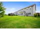 Wide shot of a large backyard features green grass, tall trees, and a multi-story house in the background at 15580 Garrano Ln, Fishers, IN 46040
