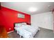 Modern bedroom with a bold red wall, patterned bedding, and minimalist decor at 15580 Garrano Ln, Fishers, IN 46040