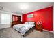 Vibrant bedroom featuring a bright red accent wall and traditional wooden furniture at 15580 Garrano Ln, Fishers, IN 46040