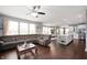 Open-concept living room with hardwood floors, a ceiling fan, and large windows offering plenty of natural light at 15580 Garrano Ln, Fishers, IN 46040