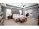 Spacious main bedroom with a large bed, tray ceiling, and sitting area at 15580 Garrano Ln, Fishers, IN 46040