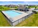 Aerial view of the fenced community pool and poolhouse, complete with lounge chairs and tables for resident enjoyment at 15580 Garrano Ln, Fishers, IN 46040