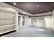 Open basement with gray floor, built in shelves, and modern lighting at 1649 Woodstock Dr, Brownsburg, IN 46112