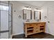Bathroom featuring a rustic vanity with dual sinks and a tiled shower at 1649 Woodstock Dr, Brownsburg, IN 46112