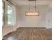 Dining room features wainscotting, wood floors, and stylish pendant light at 1649 Woodstock Dr, Brownsburg, IN 46112