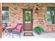 Close-up of a welcoming front door with wreath, flanked by windows and seating at 1649 Woodstock Dr, Brownsburg, IN 46112