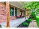 Cozy covered porch featuring wooden pillars, brick facade, and comfortable seating at 1649 Woodstock Dr, Brownsburg, IN 46112
