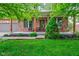 Charming front porch with brick pillars, seating area, and lush landscaping at 1649 Woodstock Dr, Brownsburg, IN 46112