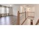 Hallway featuring a wooden railing, vinyl floors and a ceiling fan at 1649 Woodstock Dr, Brownsburg, IN 46112