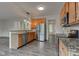 Kitchen features luxury vinyl plank flooring, wooden cabinets, and granite countertops at 1649 Woodstock Dr, Brownsburg, IN 46112