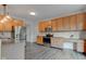 Bright kitchen with stainless appliances, granite counters, wooden cabinets, and vinyl floors at 1649 Woodstock Dr, Brownsburg, IN 46112