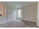 Cozy living room with plush carpet, large window, and view into the kitchen at 1649 Woodstock Dr, Brownsburg, IN 46112