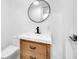 Modern bathroom featuring a wood vanity, sleek black fixtures, and a round mirror providing a clean, stylish look at 19 E Regent St, Indianapolis, IN 46225