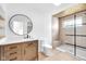 Modern bathroom with dark wood vanity, a round mirror, toilet, and walk-in shower with bench at 19 E Regent St, Indianapolis, IN 46225