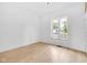 A light-filled bedroom with blonde floors features neutral walls and a bright sunny window at 19 E Regent St, Indianapolis, IN 46225