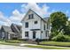 Charming two-story home with a black fence, black framed windows, and a well-manicured front yard at 19 E Regent St, Indianapolis, IN 46225
