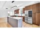 A bright, modern kitchen features stainless steel appliances, an island cooktop, and rich wood cabinetry at 19 E Regent St, Indianapolis, IN 46225