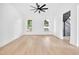Bright living room with two windows, hardwood floors, and an open entrance to the stairwell at 19 E Regent St, Indianapolis, IN 46225
