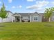 Expansive backyard with green lawn and covered patio area with outdoor seating and views of the surrounding homes at 19657 Astoria Ave, Sheridan, IN 46069