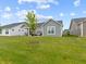 View of the rear of the house showing a large backyard and covered patio with outdoor furniture at 19657 Astoria Ave, Sheridan, IN 46069