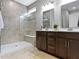 Modern bathroom featuring a tile shower with glass door, double vanity with dark wood cabinets and tile floor at 19657 Astoria Ave, Sheridan, IN 46069