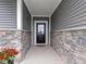 Charming front porch with stone accents and a black front door at 19657 Astoria Ave, Sheridan, IN 46069