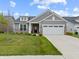 Charming home featuring a two-car garage, well-kept lawn, and stone and gray siding at 19657 Astoria Ave, Sheridan, IN 46069