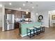 Well-lit kitchen showcasing island with seating, stainless appliances, and stylish pendant lights at 19657 Astoria Ave, Sheridan, IN 46069