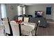 Open-concept dining area with a modern table set and a spacious living area in the background at 2263 S Carlota Dr, New Palestine, IN 46163