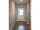 Hallway view with wood floors leading to a bright white door with glass panels at 2263 S Carlota Dr, New Palestine, IN 46163