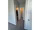 Hallway featuring neutral walls leading to an open bathroom and closet at 2263 S Carlota Dr, New Palestine, IN 46163