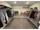 This is a carpeted walk-in closet with white wire racks, a top shelf, and a bright overhead light at 2263 S Carlota Dr, New Palestine, IN 46163