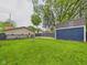 A green lawn and a storage shed accent this well-maintained fenced backyard with a small wood deck and fire pit at 2353 E 10Th St, Anderson, IN 46012