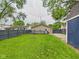 A well-kept lawn in a fenced backyard also features a small wood deck and a stone fire pit for entertaining at 2353 E 10Th St, Anderson, IN 46012