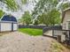 A spacious, fenced backyard features a large storage shed, a gravel area and a small wood deck for entertaining at 2353 E 10Th St, Anderson, IN 46012