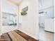 View of the hallway with rich flooring, a decorative shelf and an open view to the living room and the laundry room at 2353 E 10Th St, Anderson, IN 46012