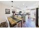 Open kitchen with a wood dining table, light cabinets, stainless steel appliances, and hardwood flooring at 2353 E 10Th St, Anderson, IN 46012
