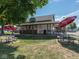 Inviting view of Alexander's Ice Cream cafe with shaded picnic tables and colorful umbrellas on a sunny day at 247 Verdant Dr, Cicero, IN 46034