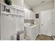 Well-lit laundry room features modern appliances, built-in storage, and an exterior door at 247 Verdant Dr, Cicero, IN 46034