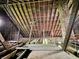 Unfinished attic with a brick chimney and some light seeping in through a window at 2606 Raible Ave, Anderson, IN 46011
