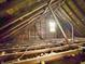 Unfinished attic with exposed beams and a single window providing natural light at 2606 Raible Ave, Anderson, IN 46011