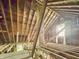 View of the unfinished attic, complete with a brick chimney and a window to let in light at 2606 Raible Ave, Anderson, IN 46011