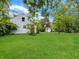 Expansive back yard with lush green lawn, mature trees, and a view of the home's exterior at 2606 Raible Ave, Anderson, IN 46011
