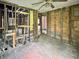 Bedroom showcasing unfinished framing and original hardwood floors, ready for personalized renovation and design at 2606 Raible Ave, Anderson, IN 46011