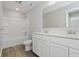 A bathroom with double sinks, tile floor, white cabinets, a large mirror and a shower/bath combo at 2693 Penn Ave, Plainfield, IN 46168
