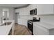 Modern kitchen with white cabinets, stainless appliances, and wood floors at 2693 Penn Ave, Plainfield, IN 46168