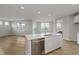 Open kitchen with white cabinets, an island, stainless appliances, and wood flooring at 2693 Penn Ave, Plainfield, IN 46168