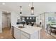 Bright open concept featuring a kitchen island open to the living room with modern fireplace at 2693 Penn Ave, Plainfield, IN 46168