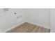 Bright laundry room with wood-look floors, washing machine hookups, and utility access at 2705 Penn Ave, Plainfield, IN 46168