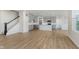 Bright and airy living space with light wood floors, stairs, and view of the kitchen area at 2705 Penn Ave, Plainfield, IN 46168